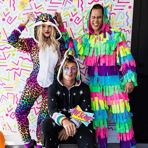 shop halloween - image of woman wearing 90s leopard costume next to two men wearing pinata costume and the other man wearing night mare unicorn costume